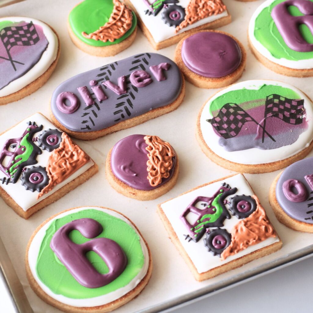 Tray of Monster Truck Themed Cookies with the number 6, racing flags, monster truck driving on dirt